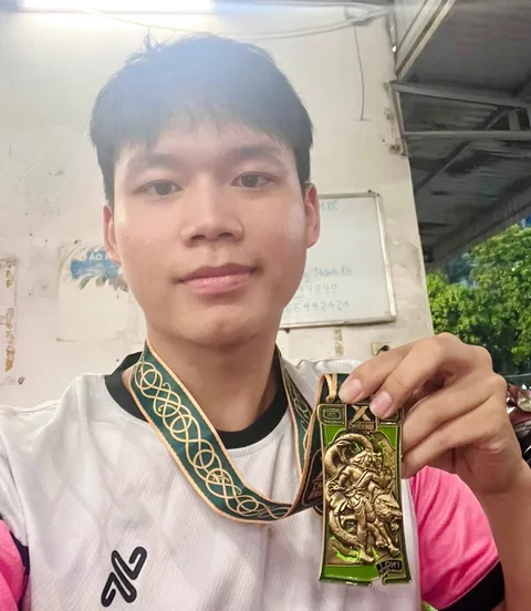 A finisher holding their X Challenge medal